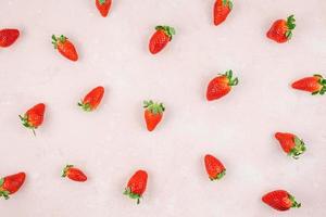 Red strawberries pattern on pink background photo