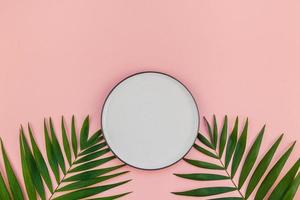 Empty plate mockup with green tropical leaves photo