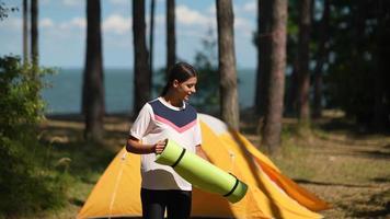 ung kvinna i de utomhus camping och håller på med yoga video