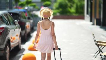 Young woman explores city while carrying luggage video