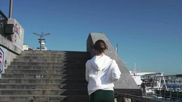 Woman exercises by climbing outdoor concrete stairs video