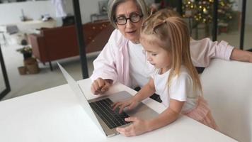 Little girl using computer at home with family video