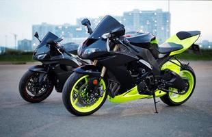 Two sports motorcycles parked on asphalt against the backdrop of the cityscape photo