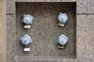 Fire hydrants embedded in the granite wall of the building. photo