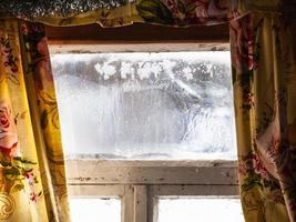 ventana congelada en mal estado en una antigua casa rural rusa foto