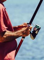 Fisherman hands holding fishing rod close up photo