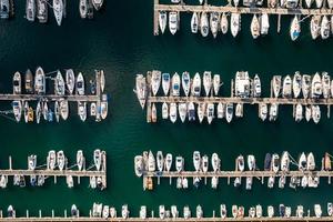 Aerial top down view of many luxurious yachts moored in marina photo