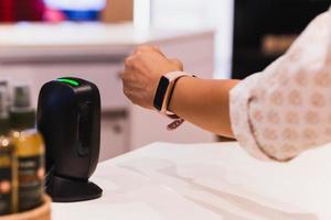 Customer making wireless payment using smartwatch at shopping store. photo