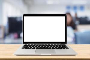 Laptop with blank screen on desk table with blur office interior background photo