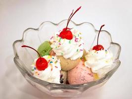 Ice cream scoops with cherry and whipped cream photo