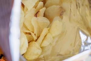 Potato chips in open snack bag close up photo