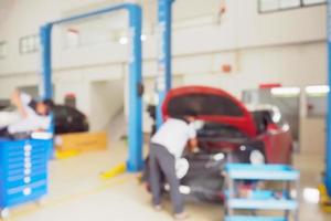 Mechanic working in car repair service centre blurred background photo