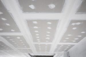 ceiling gypsum board installation at construction site photo