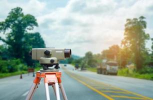 Surveyor equipment tacheometer or theodolite with road construction site background photo