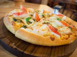 deliciosa pizza de marisco en mesa de madera foto