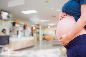 Pregnant woman with hospital blur background photo