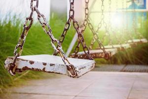 old wood swing in playground park photo