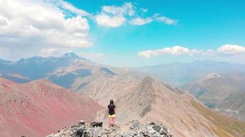 Luftbild sportliche Frau solo auf Klippe Aussichtspunkt Spaziergang erkunden Berge im Herbst Kaukasus Hintergrund in Racha, Region Georgien. Wanderweg am Udziro-See video