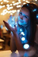 Woman holding glowing christmas garland in hands photo