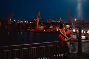 chico y chica abrazándose en un fondo del puerto nocturno foto