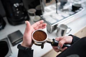 Barista holding portafilter with ground coffee photo