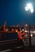 chico y chica abrazándose en un fondo del puerto nocturno foto