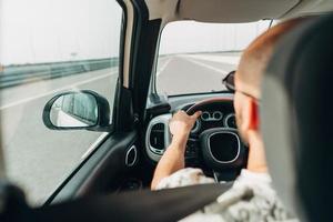 The man in the car traveling on the road photo