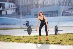 Strong woman exercising with barbell. Sports, fitness concept. photo