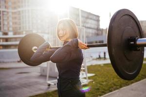 Strong woman exercising with barbell. Sports, fitness concept. photo