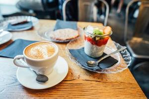 Cappuccino with spoon in cup and dessert photo