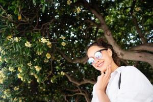 bella joven posando en el fondo de un árbol siempre verde foto