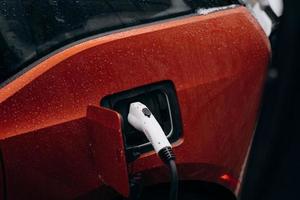 Electric car with power cable supply plugged in photo