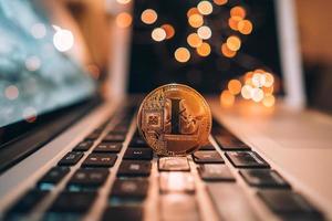 Dinero de moneda lightcoin en el teclado del ordenador portátil foto