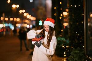 Night street portrait of young beautiful woman acting thrilled. photo