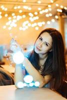 Woman holding glowing christmas garland in hands photo