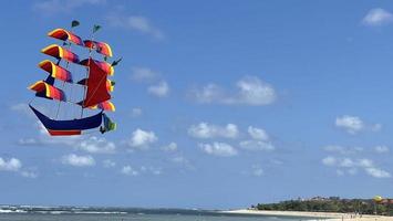 flying ship, rainbow colored ship kite flies on the blue sky and cloud photo