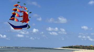 flying ship, rainbow colored ship kite flies on the blue sky and cloud photo