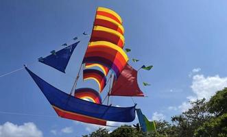 barco volador, cometa de barco de color arco iris vuela en el cielo azul y la nube foto