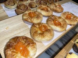 Lines of fresh baked sweet puff pastry stuffed with apricot and peach jelly photo