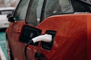 Electric car with power cable supply plugged in photo