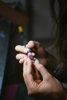 girl master processes the metal plate in the home workshop photo