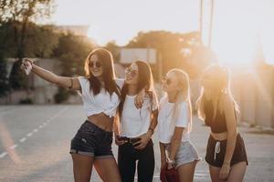 cuatro mujeres jóvenes tomándose un selfie y divirtiéndose foto