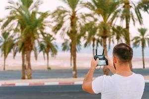 Guy controls drone with remote control photo