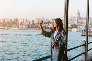 chica con el teléfono en el paseo marítimo foto