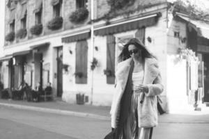 young beautiful stylish woman walking in pink coat photo