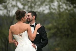 la novia y el novio bailan juntos en el bosque foto