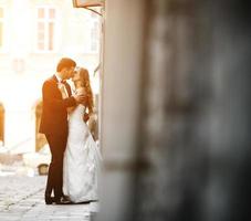 Lovely wedding couple kissing in the city photo