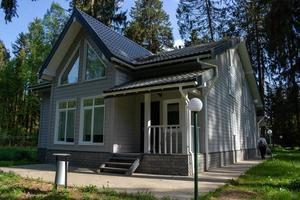 exterior de una casa moderna con un porche acabado con revestimiento gris foto