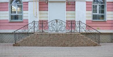 Entrance to the building.A porch with a beautiful wrought-iron railing photo