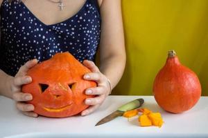 The concept of Halloween, decorations and holidays. Women's hands hold a pumpkin photo